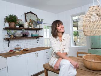 Leanne Ford poses in a newly renovated kitchen inspired by farmhouse simplicity, as seen on Restored By The Fords. (posed)